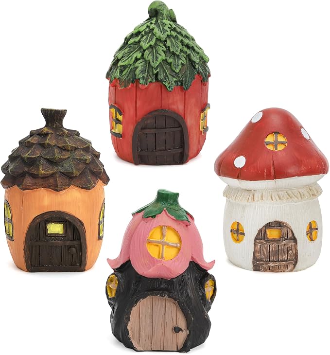Miniature fairy garden houses and resin fairy figurines arranged in an outdoor garden setting